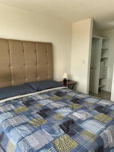 a bedroom with a bed with a quilt on it at Apartamento cómodo y exclusivo in Villa Nueva