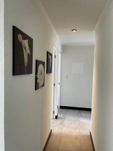 a hallway with pictures on the walls of a room at Apartamento cómodo y exclusivo in Villa Nueva