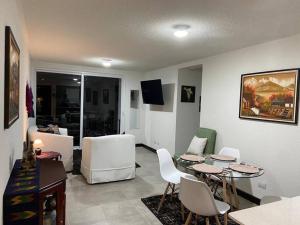 een woonkamer met een tafel en stoelen bij Apartamento cómodo y exclusivo in Villa Nueva