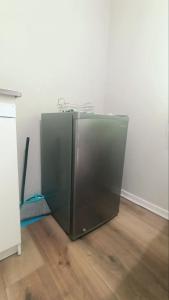 - un réfrigérateur en métal dans une chambre avec un balai dans l'établissement ApartaSuite Ñuñoa familiar con estacionamiento a pasos del Estadio Nacional e ISP, à Santiago