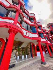 un bâtiment avec des colonnes rouges sur son côté dans l'établissement Hostal La Cocha, à Latacunga