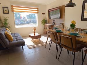 uma sala de estar com uma mesa de jantar e um sofá em Moderna y Cómoda Casa - Vista Al Volcán em Villarrica