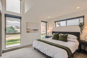 a bedroom with a large bed and windows at Upscale Townhome w/ Stunning Rooftop Views in Denver