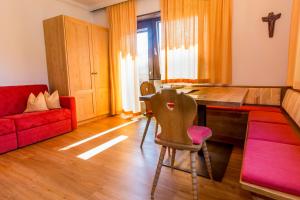 Una sala de estar con una mesa y un sofá rojo. en Ferienland Stubai, en Fulpmes