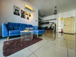 een woonkamer met een blauwe bank en een tafel bij Atlantis Residence B19 5-6 pax l 5 mins Jonker St by Lullaby Retreats in Melaka