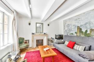 a living room with a gray couch and a fireplace at Pinède house furnished in Aix-en-Provence