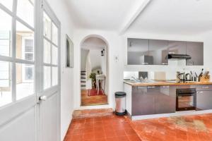 a kitchen with white walls and a large window at Pinède house furnished in Aix-en-Provence