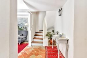 a hallway with white walls and a staircase with a red rug at Pinède house furnished in Aix-en-Provence