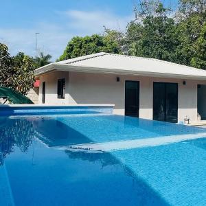 una casa con una piscina azul frente a ella en Villa Estrella Pavones en Pavones