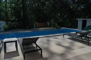 un patio con 2 sillas y una piscina en Villa Estrella Pavones en Pavones