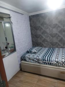 a small bedroom with a bed and a mirror at Casa simples e aconchegante / Banho quente in Contagem