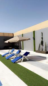 卡拉克的住宿－شاليه نايا，游泳池畔的2把躺椅和遮阳伞