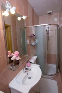 uma casa de banho com um lavatório branco e um chuveiro em Rooms Kapelj em Postojna