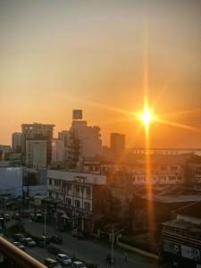 a city skyline with the sun setting in the sky at Hannatel Rooms Liberté in Douala