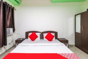a bedroom with a large bed with red pillows at OYO Flagship 62748 Hotel Zeenat in Jammu