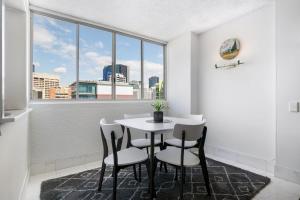 a table and chairs in a room with a window at Picturesque City Living Moments From Everything in Brisbane