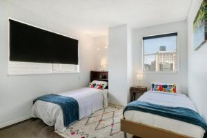 a bedroom with two beds and a flat screen tv at Picturesque City Living Moments From Everything in Brisbane