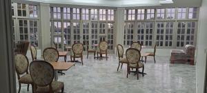 uma grande sala com mesas, cadeiras e janelas em Yatu Lau Lagoon Resort Fiji em Pacific Harbour