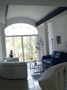 a living room with two couches and a large window at Habitación con balcón en una Mansión in Tegucigalpa