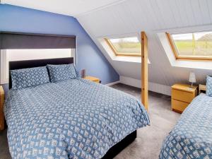 a bedroom with two beds and two windows at Rose Cottage in Slaley
