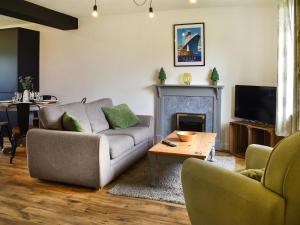 a living room with a couch and a fireplace at The Hayloft - Uk46186 in St Margarets at Cliff