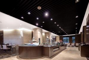 a restaurant with a counter with chairs and tables at Newyantai Hotel Hainan in Haikou