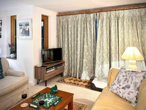 ein Wohnzimmer mit einem Sofa und einem TV in der Unterkunft East View in Langton Matravers