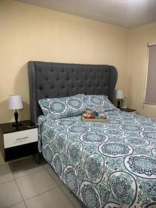 - une chambre avec un lit et une couette bleue et blanche dans l'établissement Cozy and relaxing apartment, à Guatemala