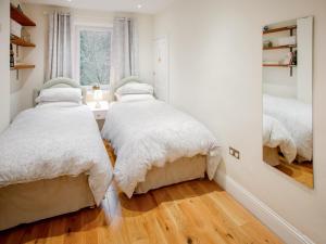 a bedroom with two beds and a window at Brookside Cottage in Copley