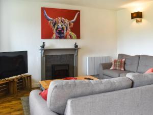 uma sala de estar com dois sofás e uma pintura de um touro em The Granary - Uk46187 em St Margarets at Cliff