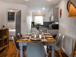 uma mesa de jantar com cadeiras e uma cozinha em The Granary - Uk46187 em St Margarets at Cliff
