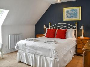 a bedroom with a large white bed with red pillows at The Granary - Uk46187 in St Margarets at Cliff