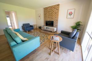 ein Wohnzimmer mit 2 blauen Sofas und einem TV in der Unterkunft The Royal Cottage in Mildura