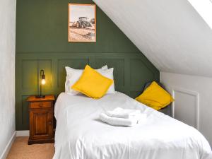 - une chambre avec un lit blanc et des oreillers jaunes dans l'établissement The Dairy - Uk46188, à St Margarets at Cliff