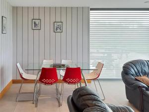 a dining room with a glass table and red chairs at Park Barn in Whittington