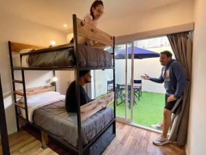 two men standing in a room with bunk beds at Alfonsina Hostel in Buenos Aires