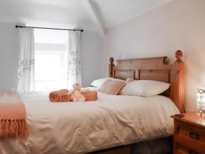 un dormitorio con una cama con dos animales de peluche en Chapel Street Cottage, en Amlwch