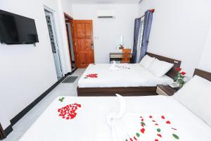 um quarto com duas camas e uma tv nele em Khách sạn Ciao Quy Nhơn em Quy Nhon