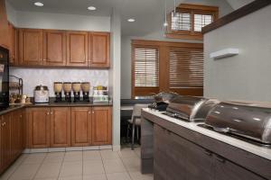 a kitchen with wooden cabinets and a counter top at Residence Inn by Marriott San Bernardino in San Bernardino