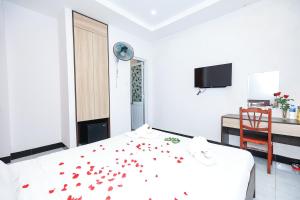 um quarto com uma cama com pétalas vermelhas em Khách sạn Ciao Quy Nhơn em Quy Nhon