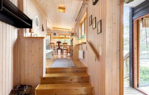 Gorgeous Home In Hrnsand With Wifi في هارنوساند: منزل صغير مع درج خشبي يؤدي إلى غرفة طعام