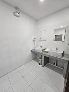 a bathroom with two sinks and a mirror at Tiger House Hostel Koh Tao in Koh Tao