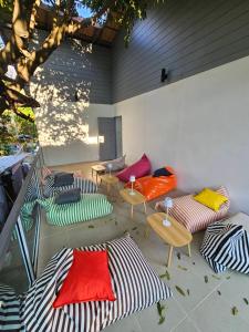 タオ島にあるTiger House Hostel Koh Taoのカラフルなソファとテーブル、木が備わるお部屋