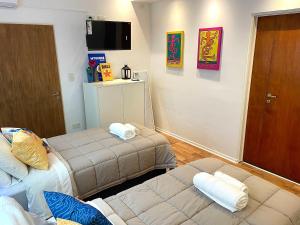 Habitación pequeña con 2 camas y TV. en Alfonsina Hostel en Buenos Aires