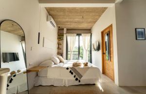 a bedroom with a large bed and a mirror at Alma Tropical - Luxury Villa Experience in Santa Teresa in Santa Teresa Beach