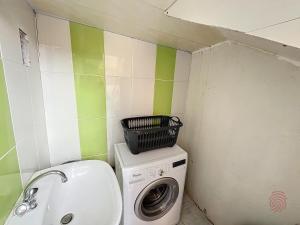 lavadero con lavadora y cesta en la parte superior en Appartement Lamalou-les-Bains, 2 pièces, 2 personnes - FR-1-451-202, en Lamalou-les-Bains