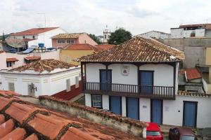 Un edificio blanco con un balcón en lo alto de los tejados. en LINDA CASA NO CENTRO HISTÓRICO, en São João del Rei