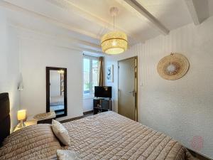 1 dormitorio con cama, espejo y TV en Appartement Lamalou-les-Bains, 2 pièces, 2 personnes - FR-1-451-202 en Lamalou-les-Bains