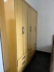 um grande armário de madeira com alças de prata num quarto em Apto duplex, frente ao mar. em São Vicente