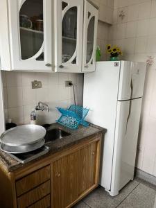 uma cozinha com um lavatório e um frigorífico branco em Apto duplex, frente ao mar. em São Vicente